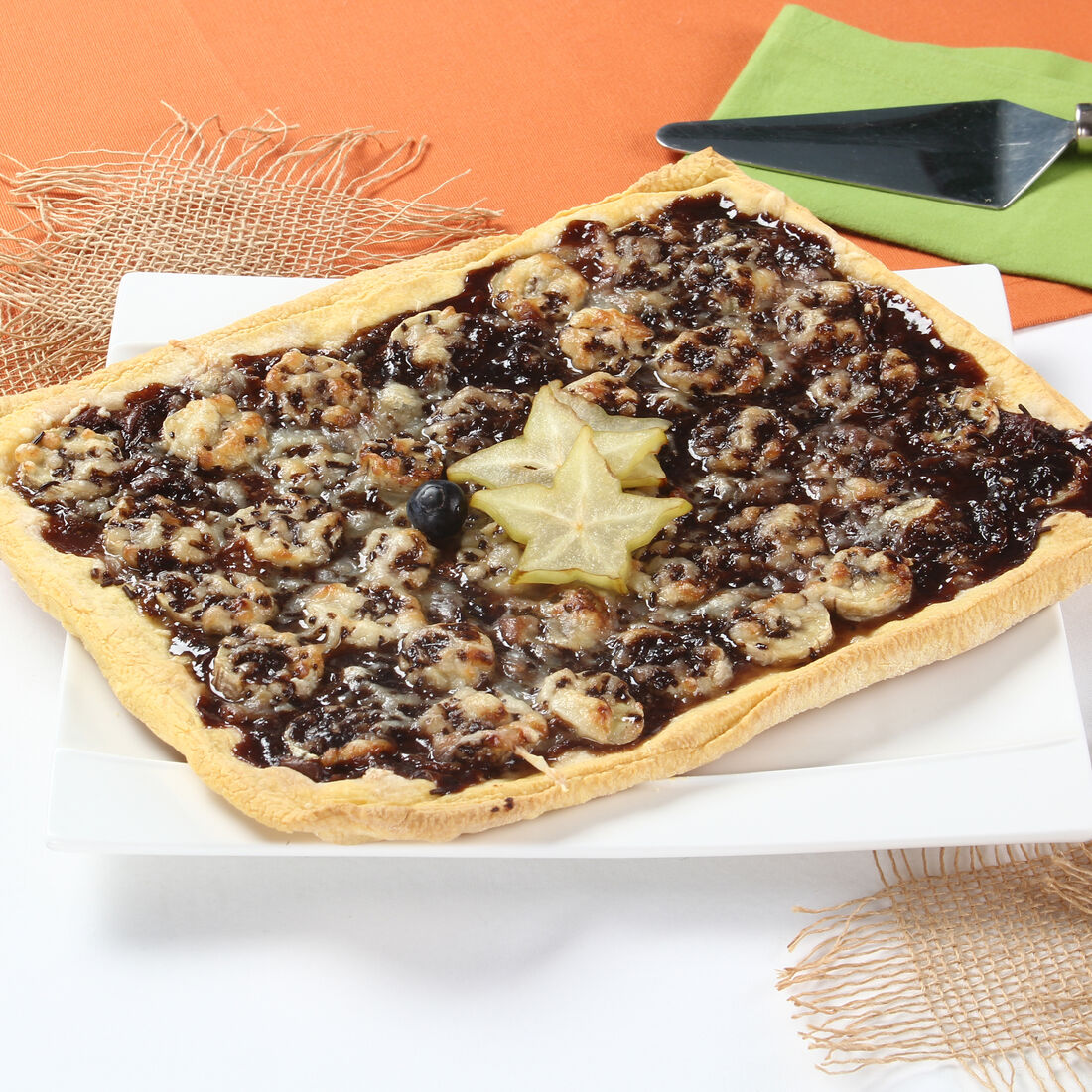 Piza de chocolate e banana com carambola e mirtilo