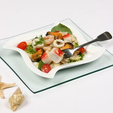 Salada de frutos do mar com camarão, mexilhão e lula num prato branco