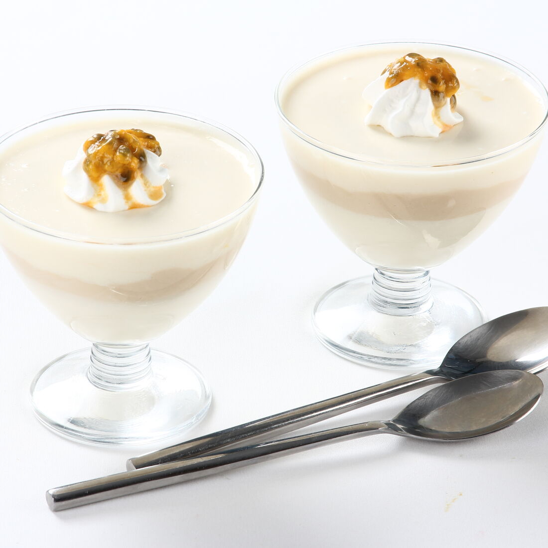 Musse de maracujá e café com chantilly servida em taças com colheres