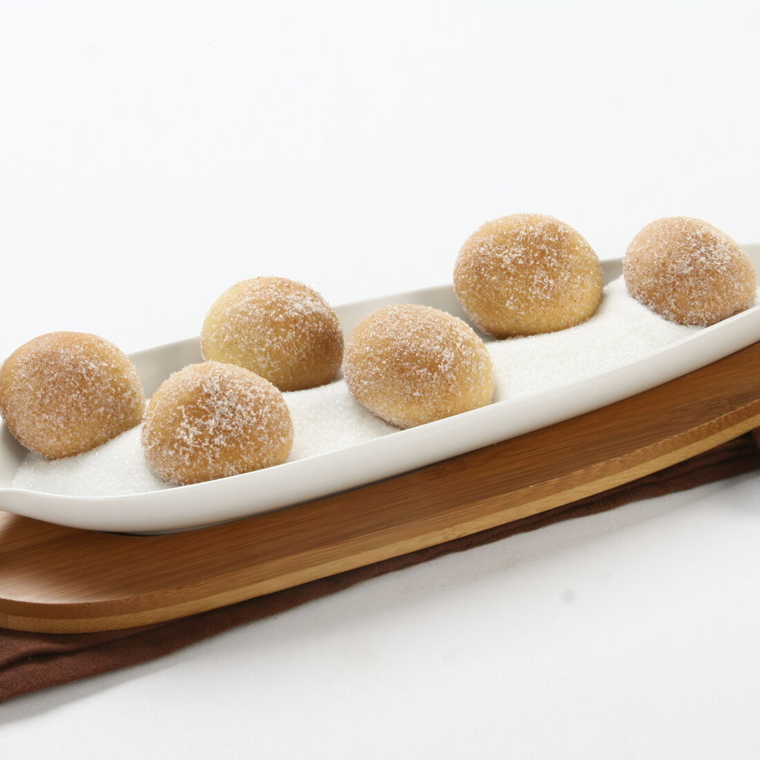 Bolinhos Areados num prato branco com açúcar e canela