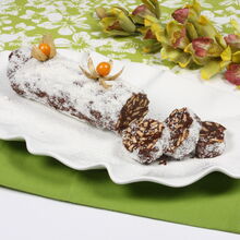 Salame de chocolate com coco e physalis em prato branco