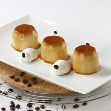 Três pudins de café com chantilly e grãos de café