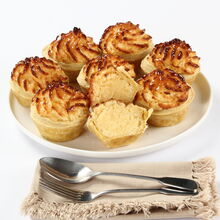 Pastéis de coco apresentados numa travessa com talheres