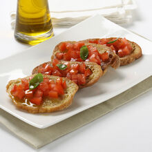 Bruschettas com tomate e manjericão num prato com azeite