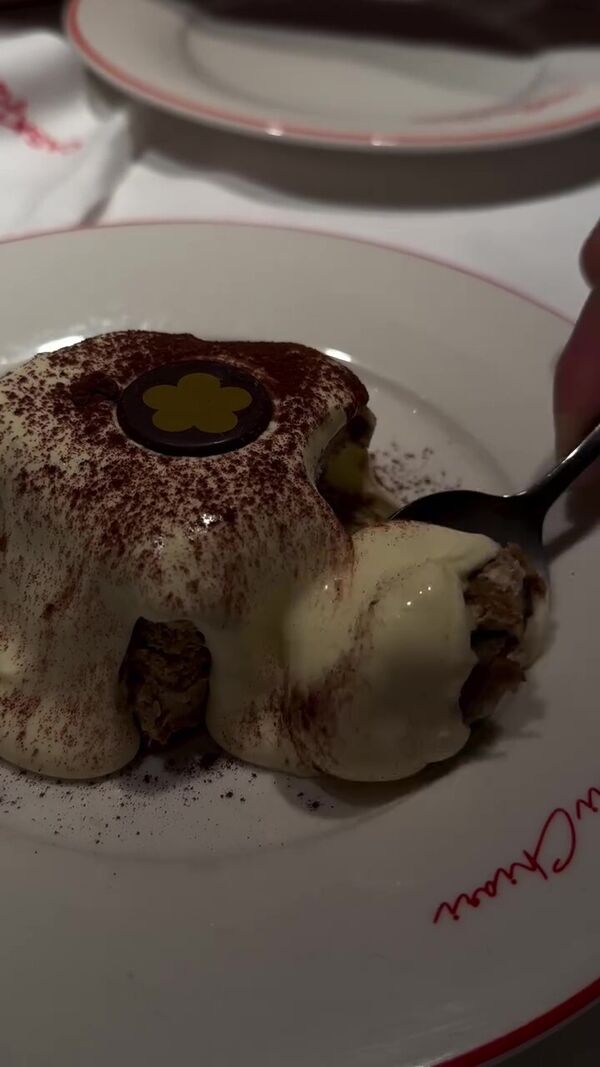 Uma sobremesa de tiramisú a ser servida num prato com o nome da marca