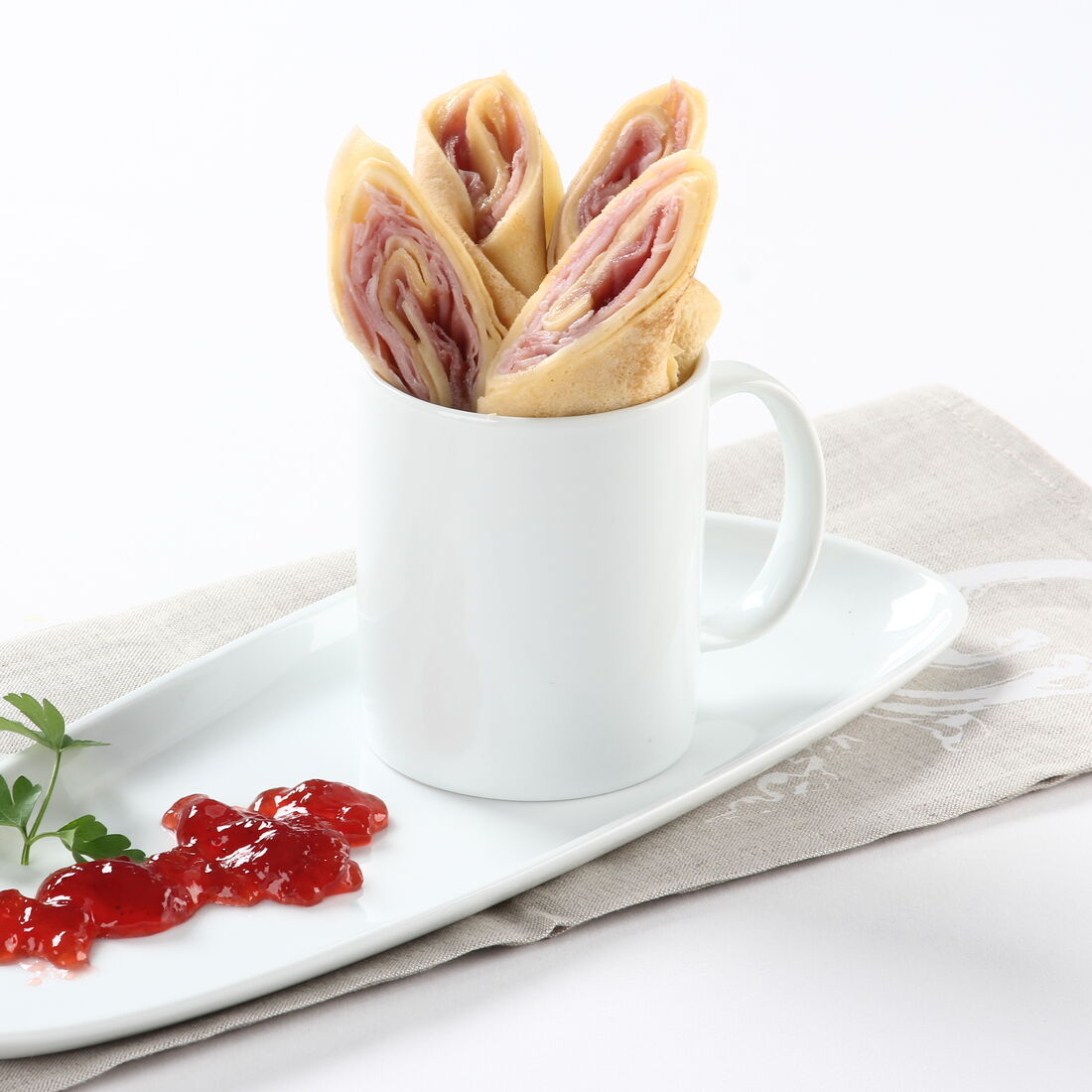 Crepes enrolados com fiambre e queijo, servidos com compota