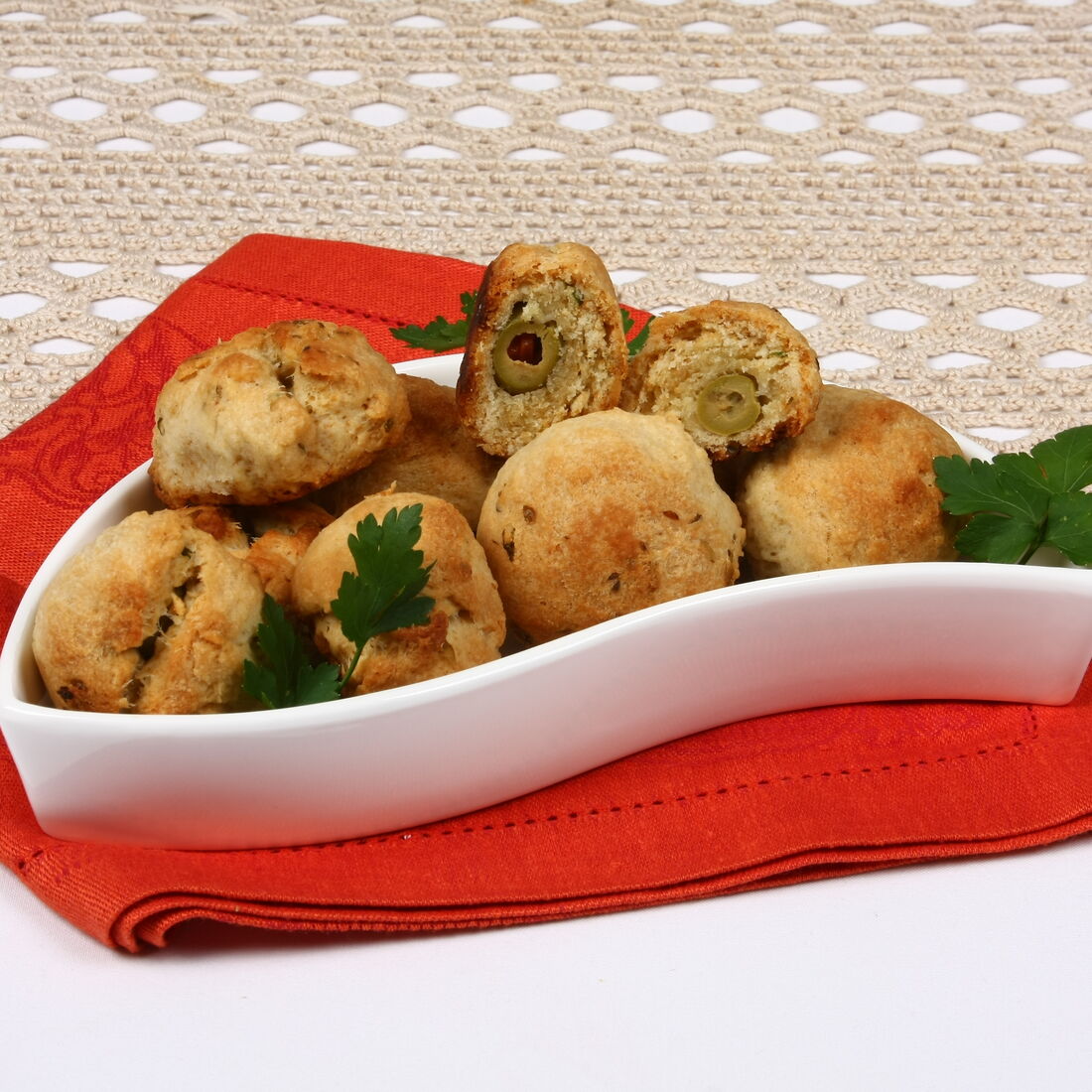 Bolinhos de azeitona num prato branco com salsa picada