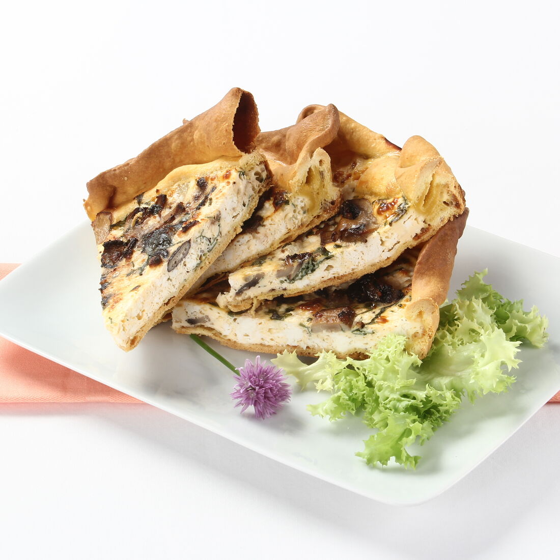 Fatias de tarte de cogumelos com queijo e alface numa travessa