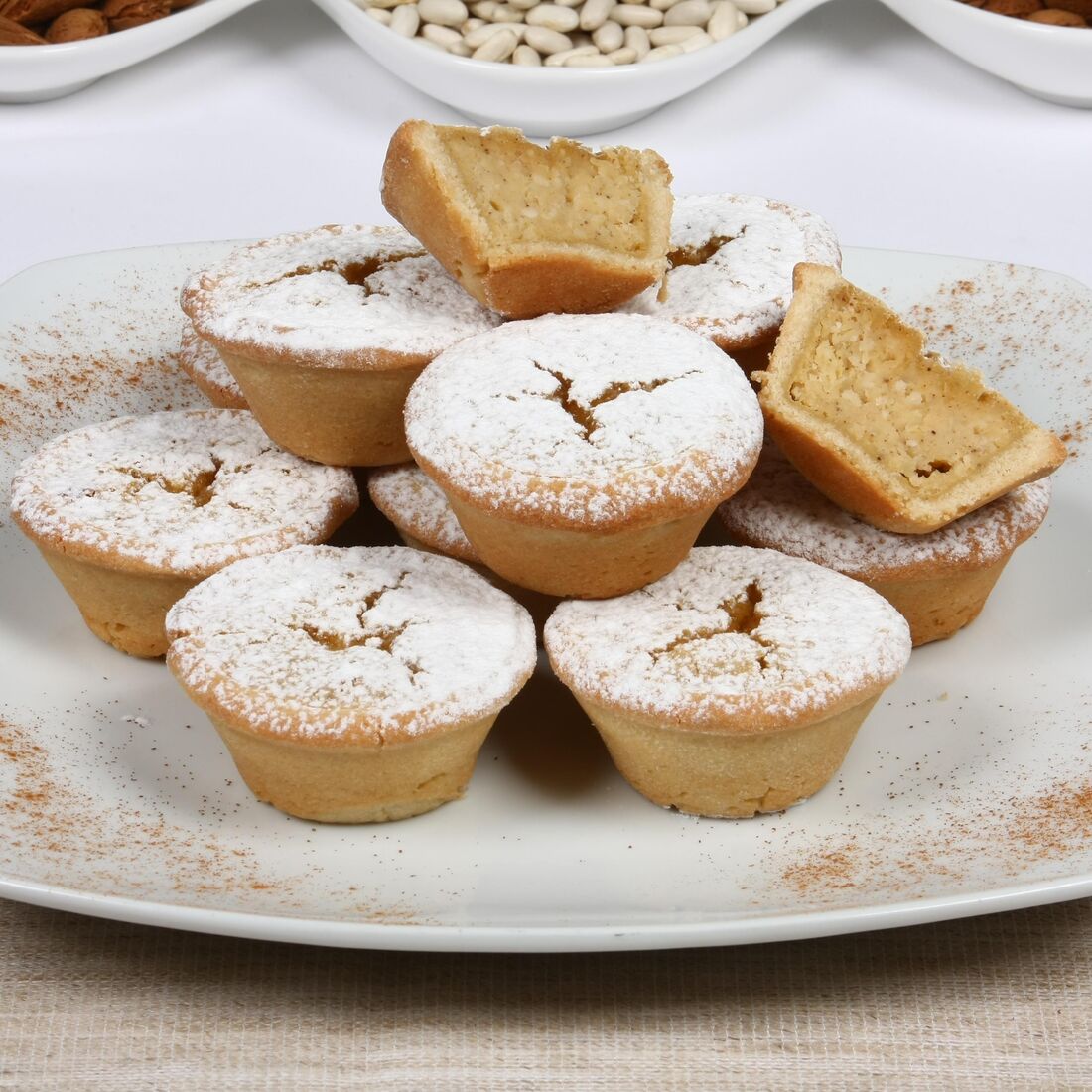 Pastéis de feijão com açúcar em pó e canela numa travessa