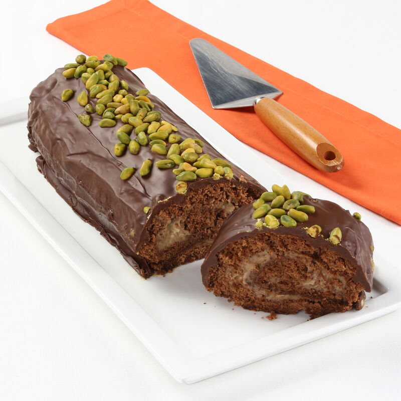 Torta de chocolate com pistácios servida numa travessa branca